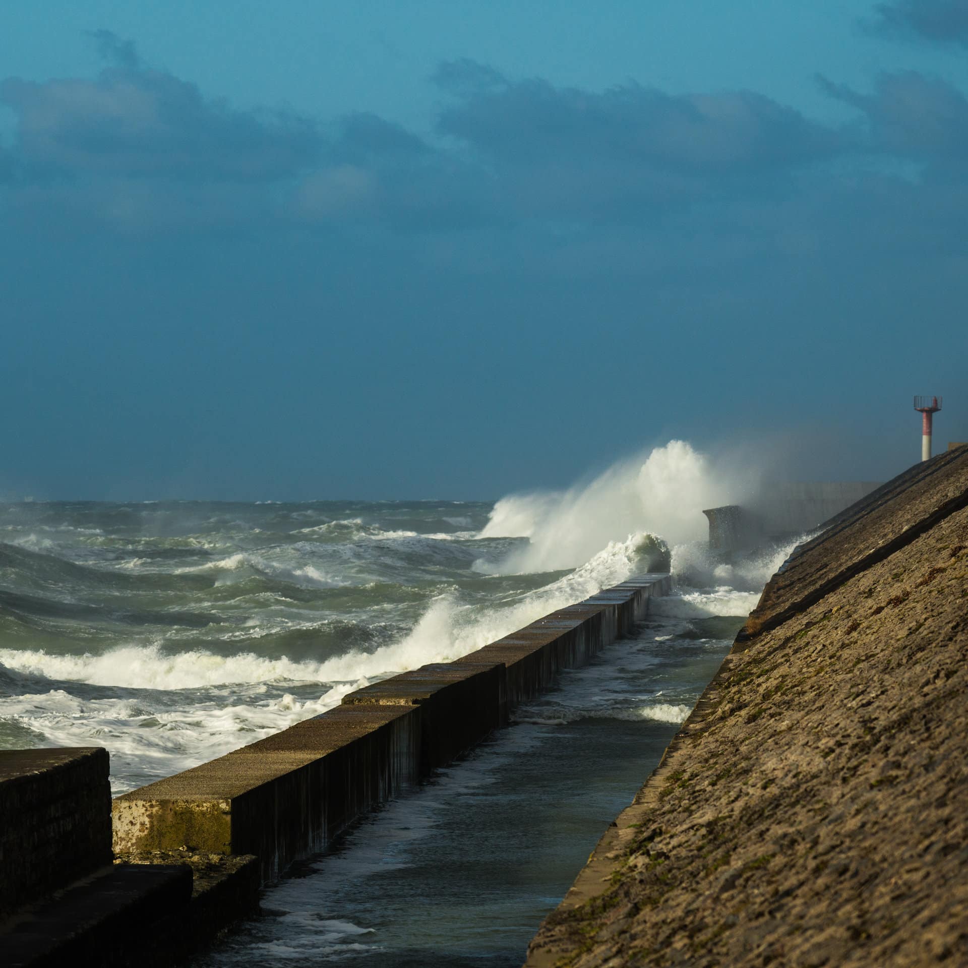 Wave crash into the harbour wall at Calais, France.