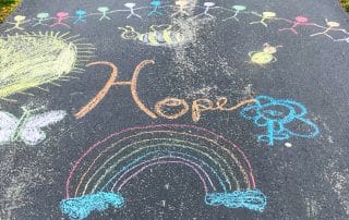 The word "hope" chalkmarker on the pavement.