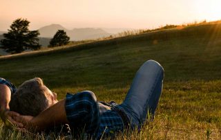 A man laying peacefully in a field.
