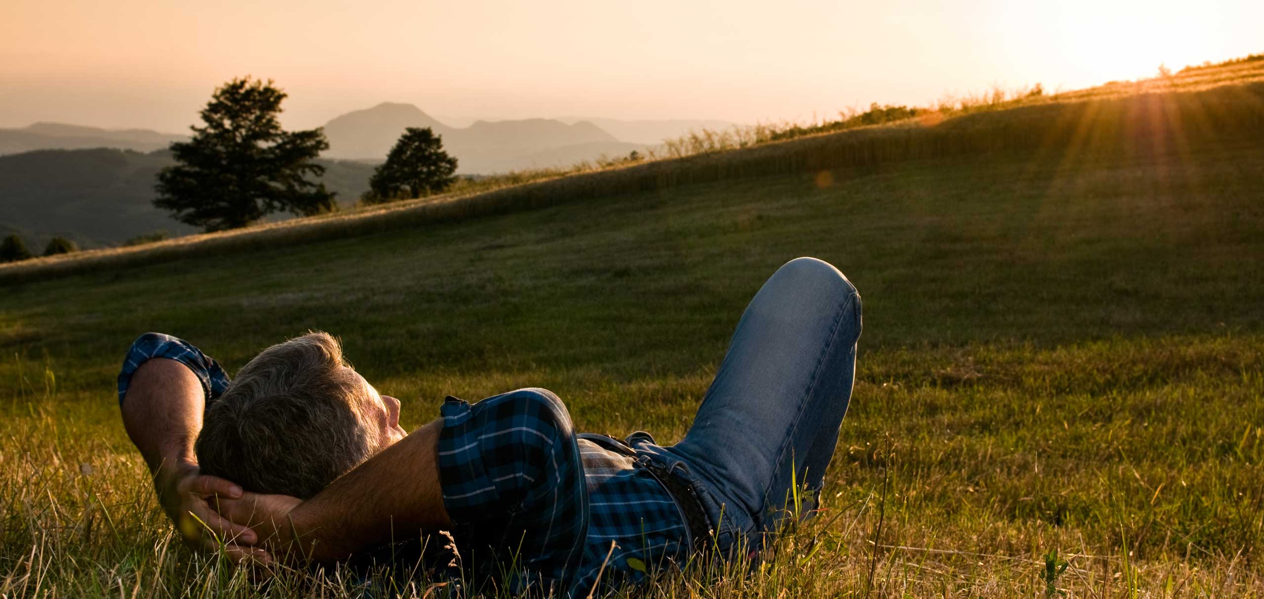 A man laying peacefully in a field.