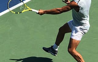 Rafael Nadal hitting a ball on the tennis court.