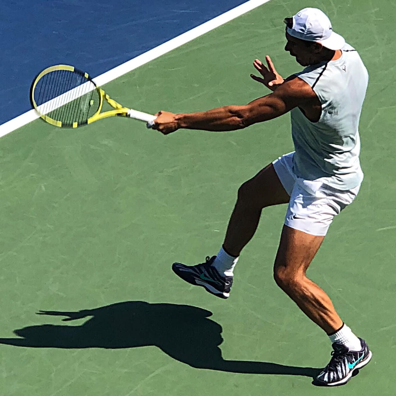 Rafael Nadal hitting a ball on the tennis court.