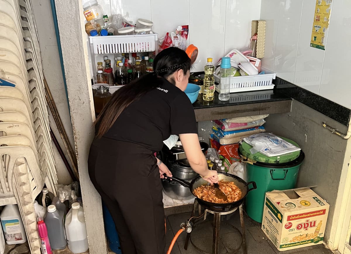 A staff member cooking food at The Hub, Bangkok.