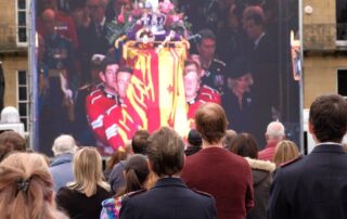 Crowds gather to watch the funeral of Queen Elizabeth II on big screens.