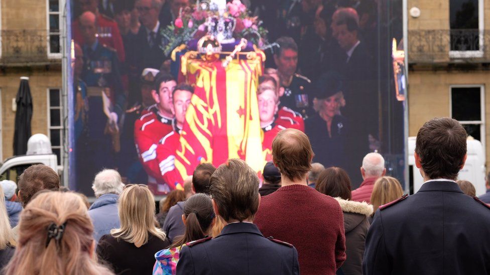 Crowds gather to watch the funeral of Queen Elizabeth II on big screens.