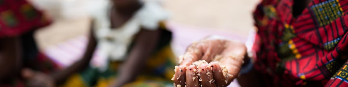 A starving woman holds out her hand for food in Africa, a global famine hotspot.