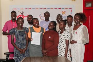 A group of ten South Sudanese aid and humanitarian works pose for a group photo in their office.